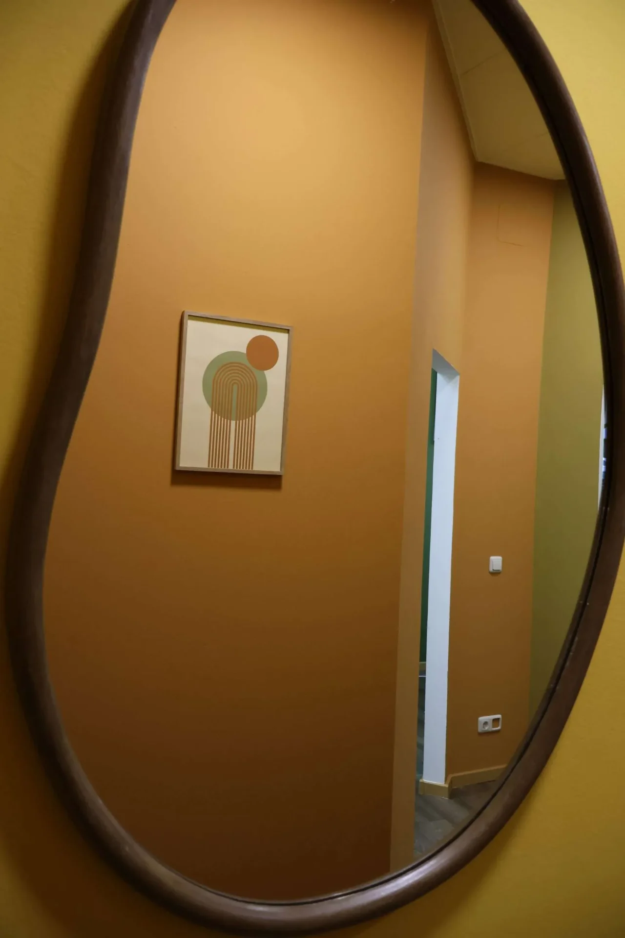 Detail: Spiegel und warme Wandfarbe